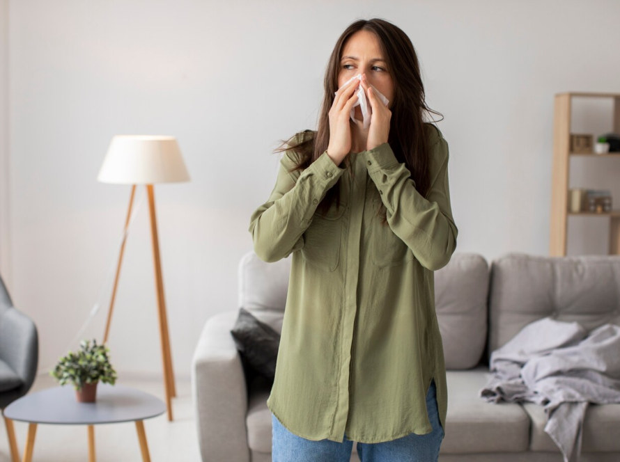 Woman experiencing allergy symptoms indoors, possibly due to poor indoor air quality.