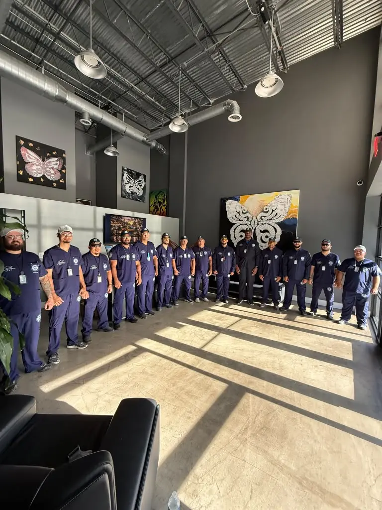 FixMold Miami team standing with service vans at golden hour